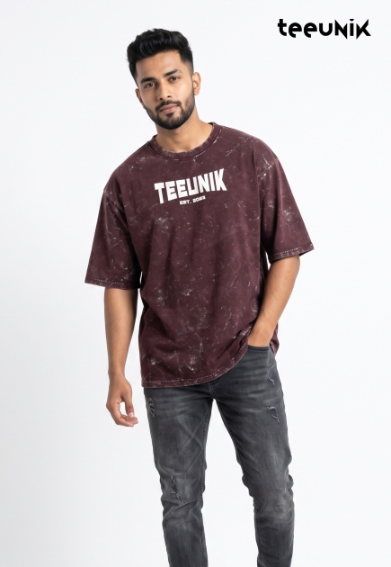 A maroon acid-wash streetwear t-shirt featuring a dropped shoulder design, relaxed fit, and the white TEEUNIK EST. 2023 logo.