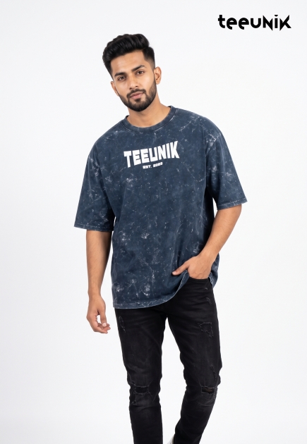 A navy blue acid-wash streetwear t-shirt featuring a dropped shoulder design, relaxed fit, and the white TEEUNIK EST. 2023 logo.